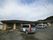 山のある背景に立地している平屋建ての施設。前面には駐車場が完備されている。4台の乗用車が停車している。
