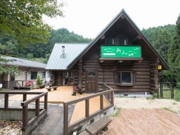 ログハウス風の外観のグループホームの様子。自然に囲まれた建物