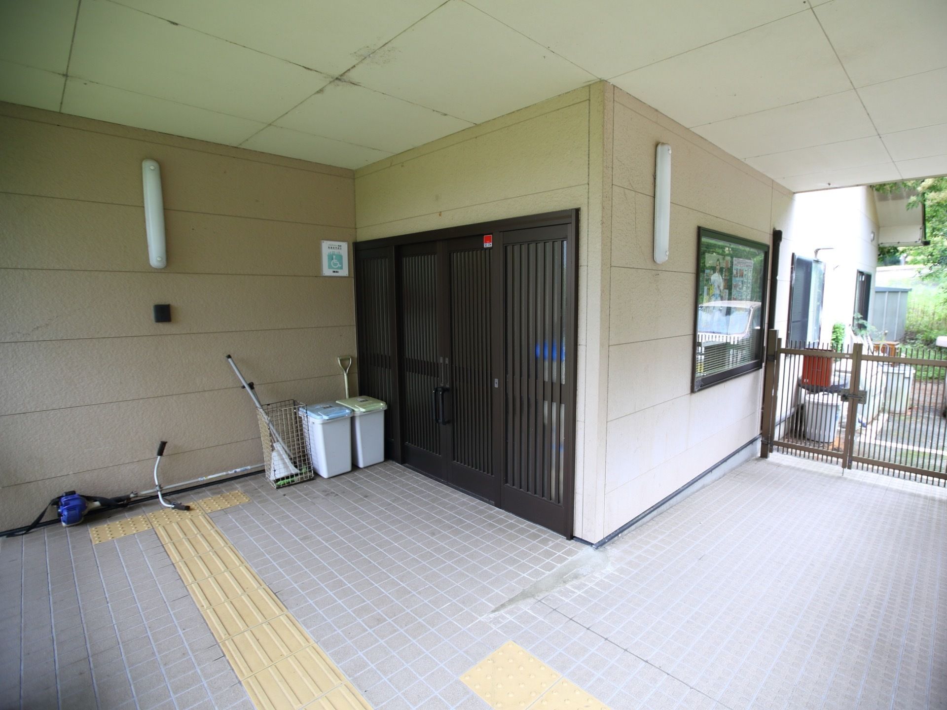 クリーム色を基調とした広々とした玄関で、床は灰色のタイルが貼られている。緩やかなスロープと点字ブロックが設置されている。