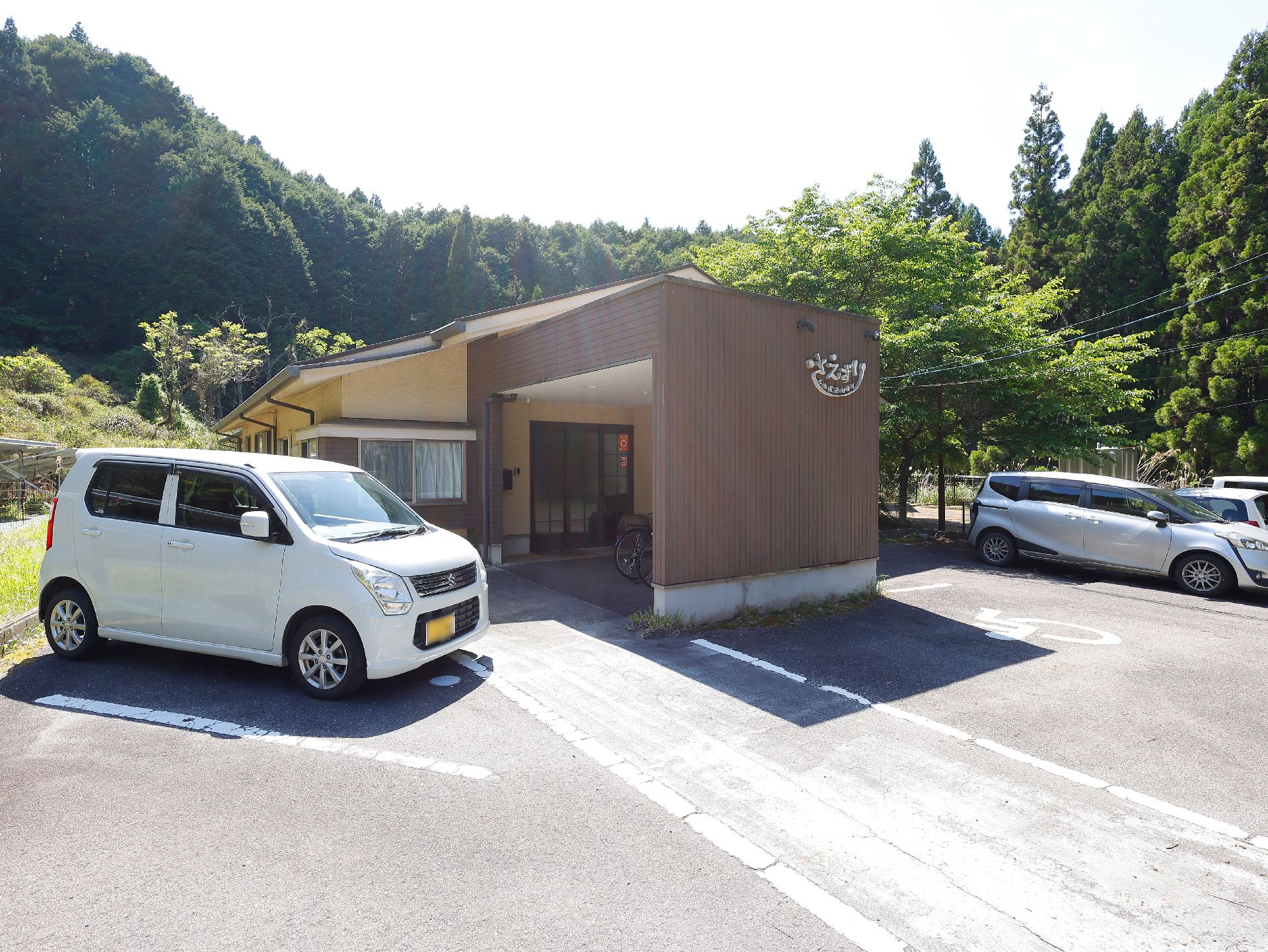 駐車場と車寄せのある高齢者施設の外観