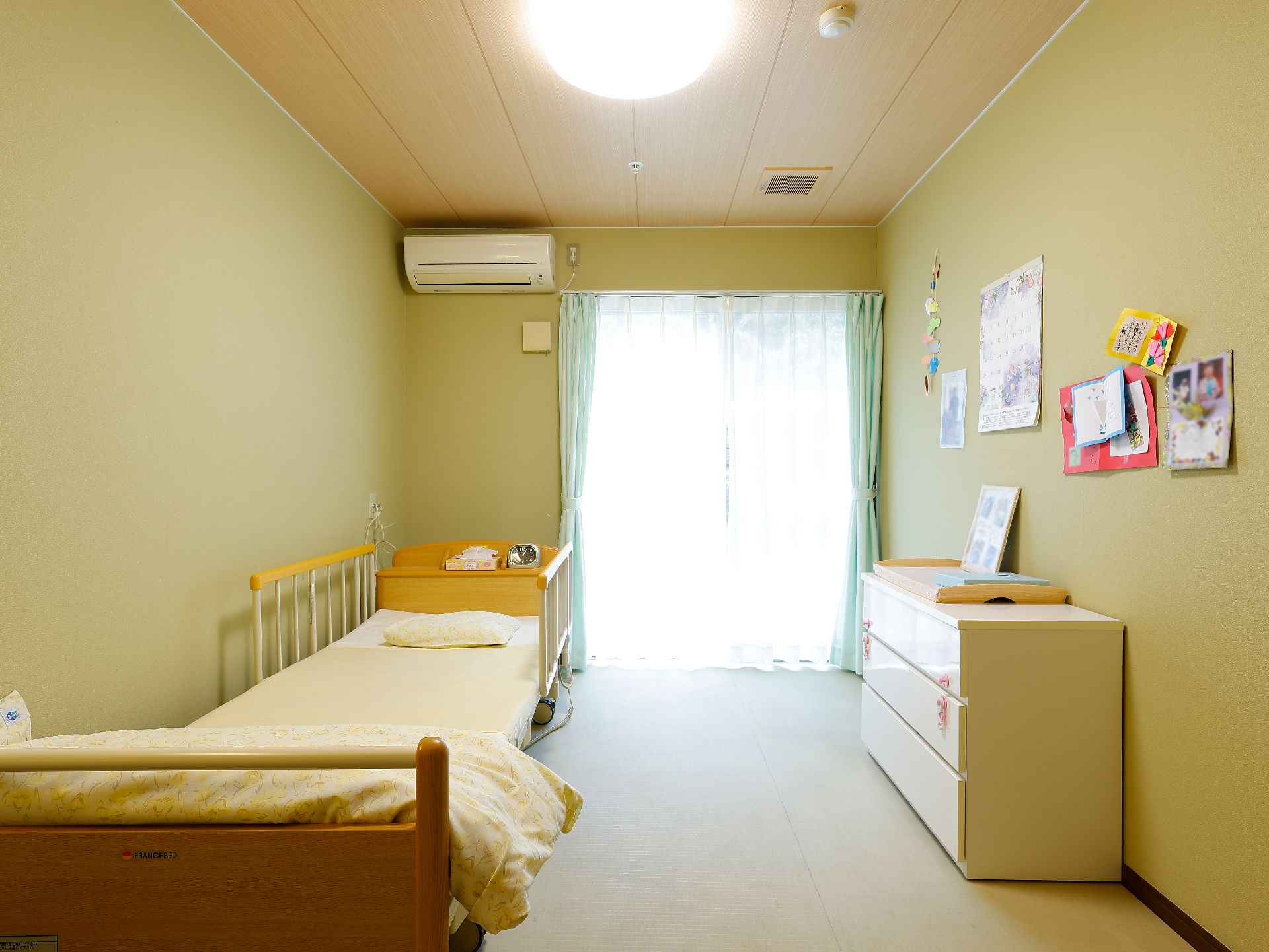 ベッドやチェストが設置された高齢者施設の居室