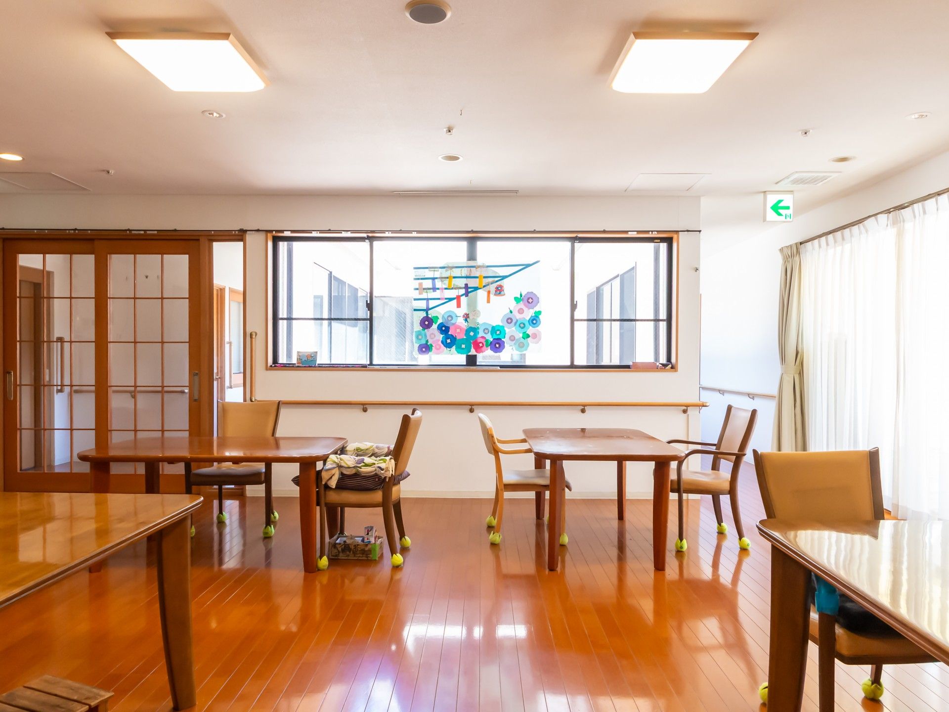 車椅子に座った高齢女性と寄り添う女性ヘルパー