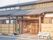 木造建築で、温かみのある雰囲気。瓦屋根で、玄関先にはベンチが置かれ、プランターも並んでいる。