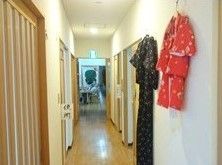 廊下には和風の服がかけられ、各ドアは引き戸、トイレには「便所」と書かれている。