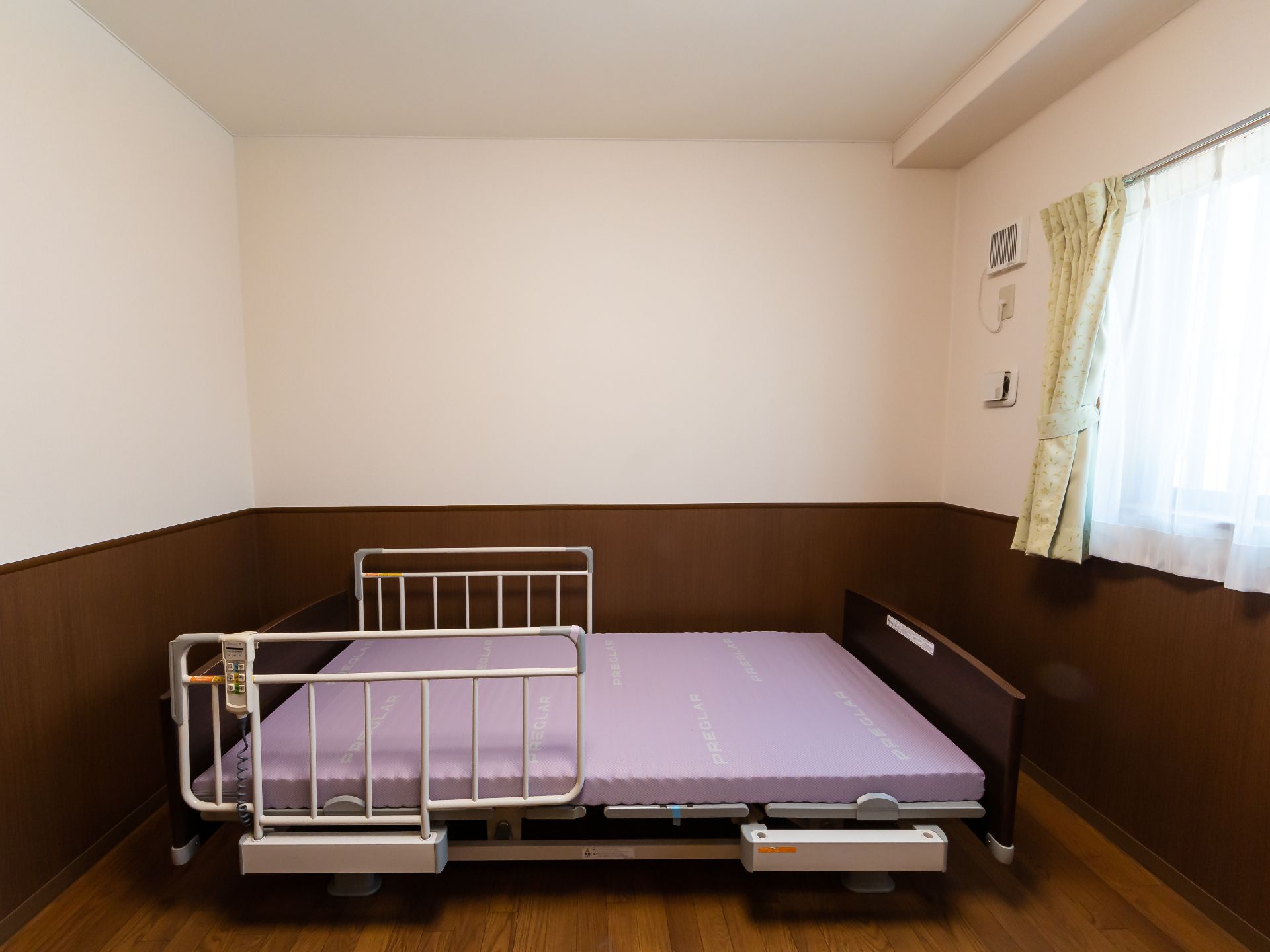 白衣を着た女性スタッフと高齢女性たちがベージュのソファを囲んで楽しそうに話をしている。