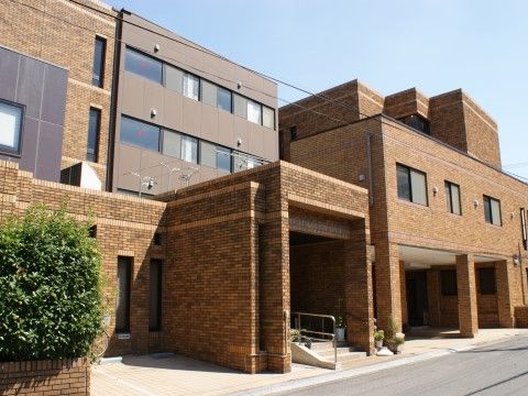 黄土色のレンガ造りの外壁を持つ、デザイン性のある施設の外観