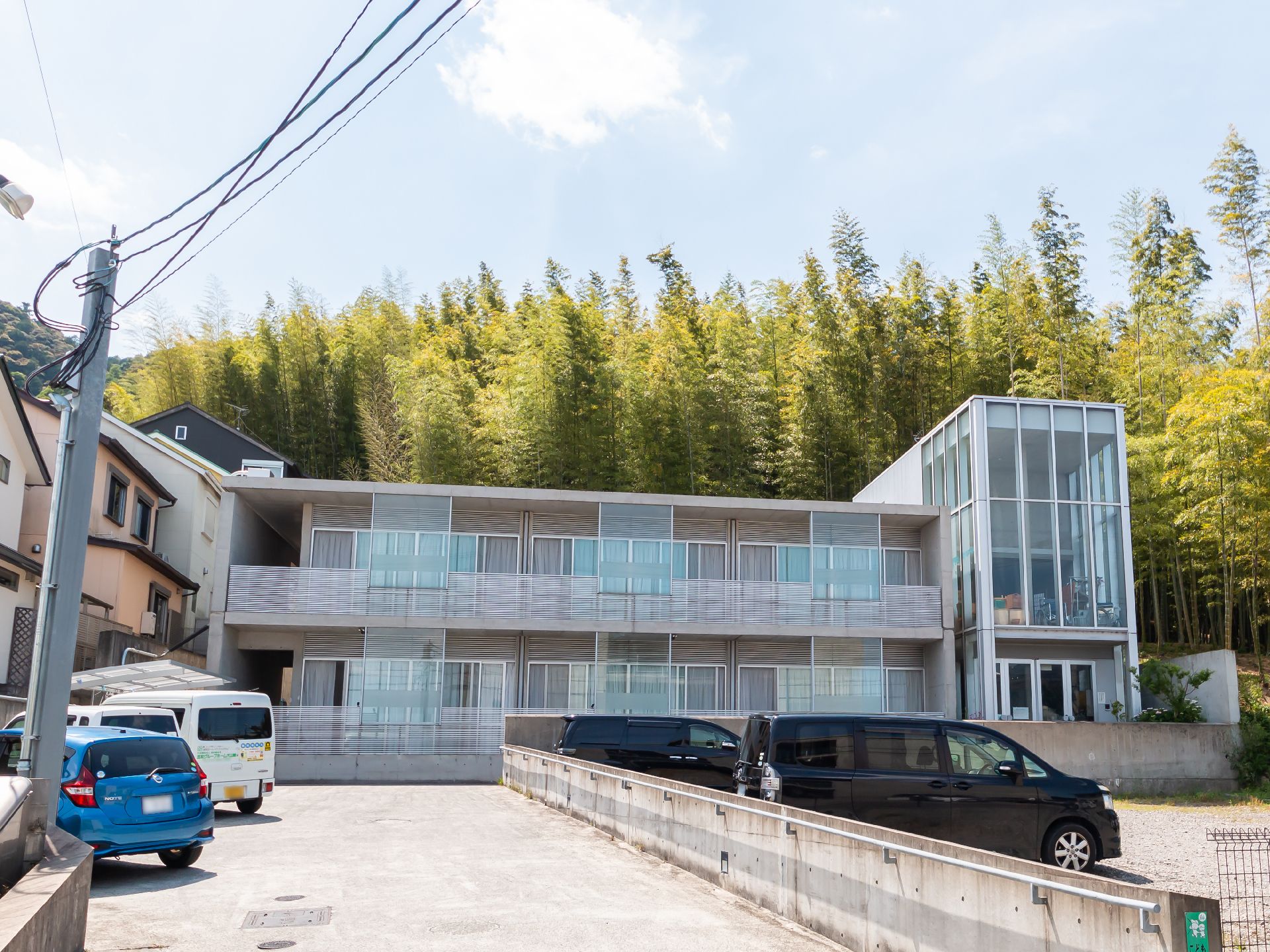 樹木が茂る山と高齢者施設の外観