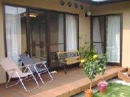一軒家の縁側にリラックス用の椅子が並んでいる様子。右側に中庭がある家