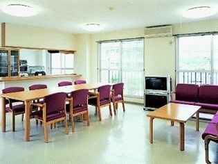 木製のダイニングテーブルが置かれたリビングダイニングにはテレビが置かれ、対面式キッチンもある。