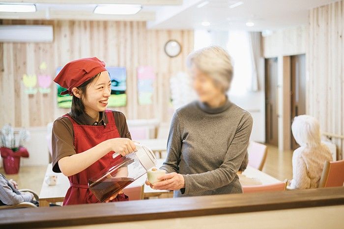 笑顔で飲み物を提供する場面