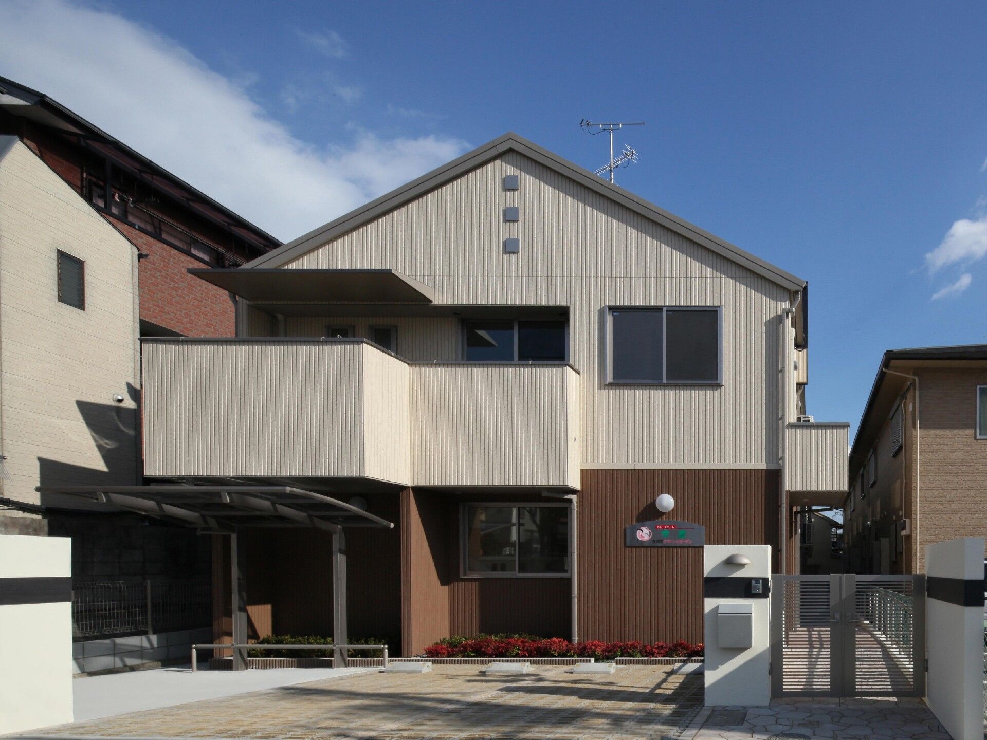 ベージュとブラウンの2階建ての建物。アットホームな雰囲気。