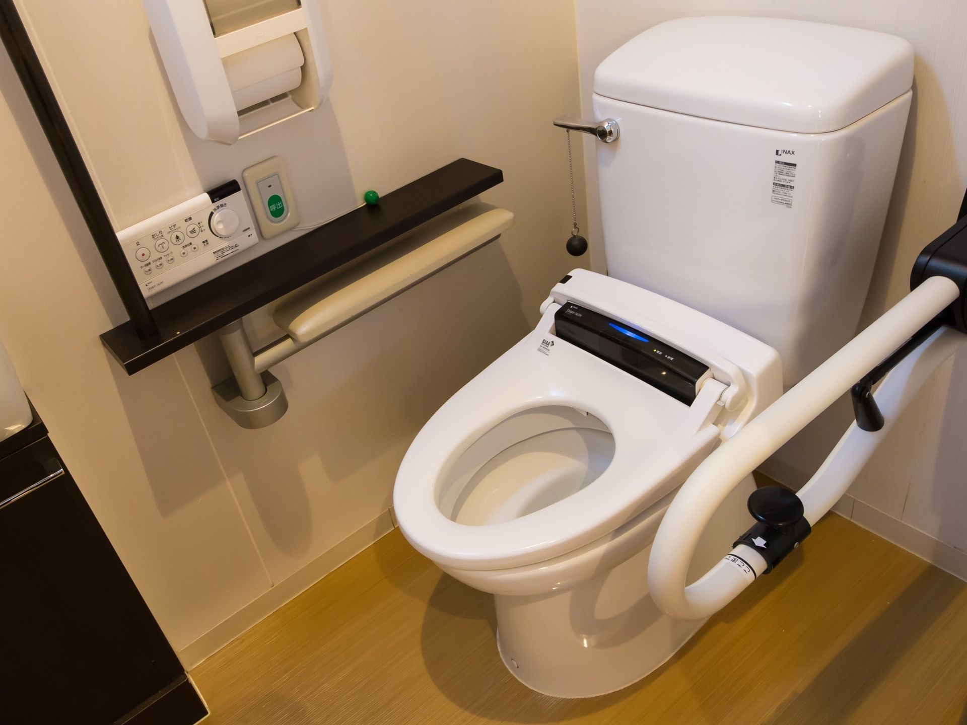 トイレはモノトーン調を採用している。白い取っ手の金具が黒く、白い壁には黒い台が付いている。ダイヤルで水量が調節できる操作パネルは壁にある。