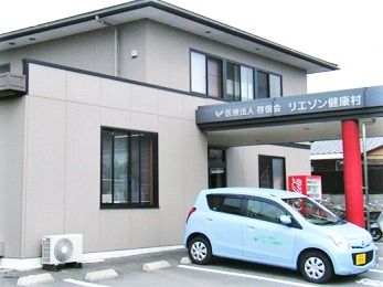 ２階建ての一軒家のような外観写真。エントランス部分に雨除けのひさしがある様子