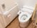 取っ手がついた引き戸を開けるとトイレが設置されている。水洗のボタンが、トイレットペーパーホルダーの上に取り付けられている。