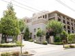 緑豊かな木々や植物が植えられておりベージュ色の建物と相まってお洒落である。レンガの門が設置されている。