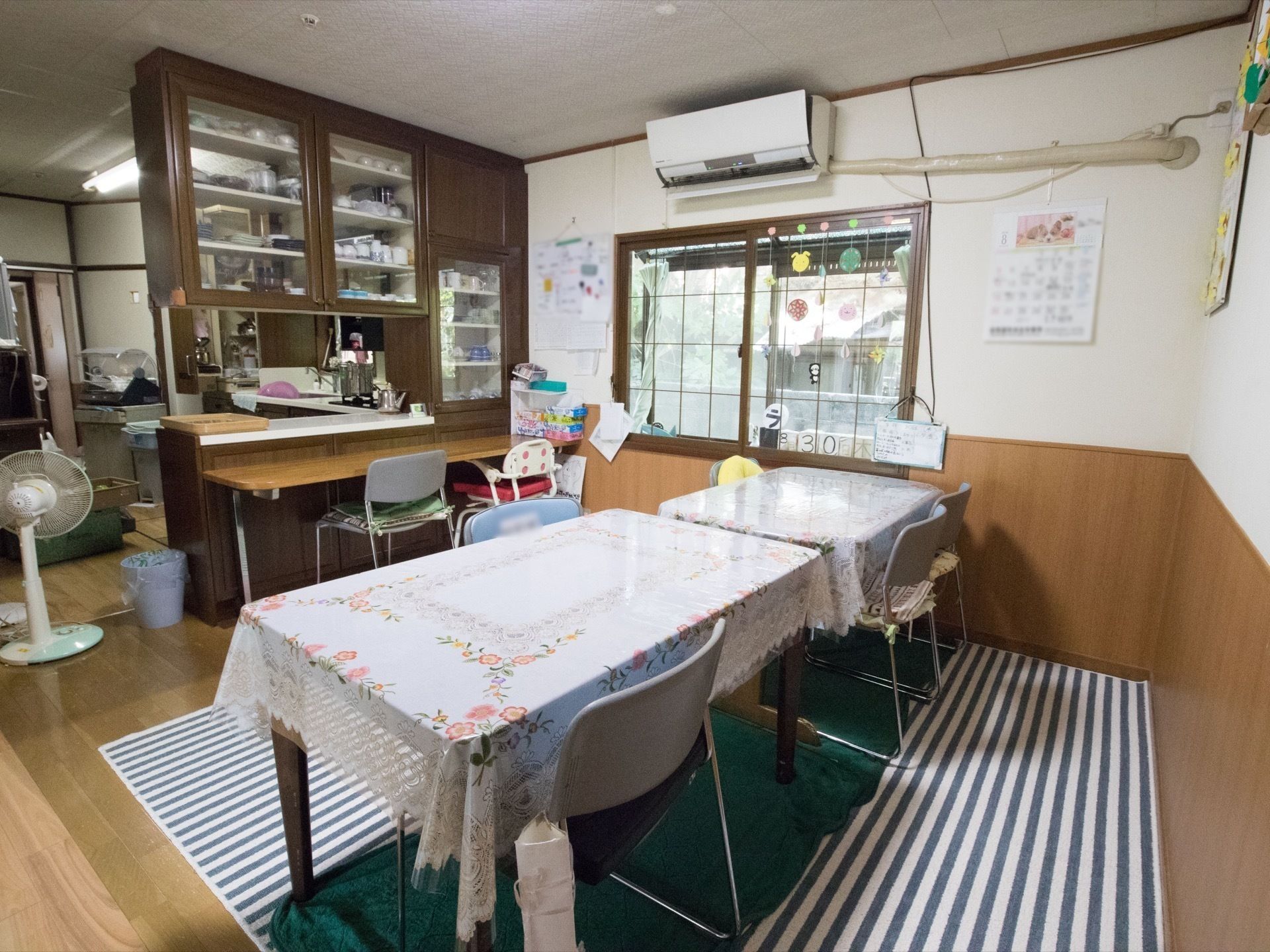 草原で笑顔で寄り添うおじいさんとおばあさんと若い女性