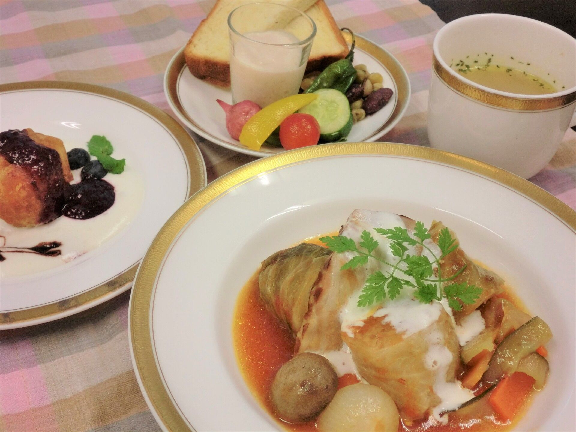 黒いお盆の上にはその日の食事が配膳されている。かけそば、きゅうりともずくの和え物、肉まん、わらび餅がそれぞれお皿に入れられている。