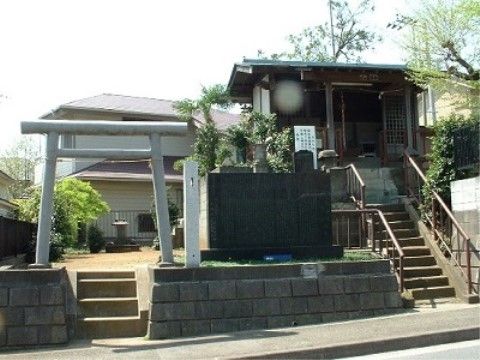 歩道から小さな階段を上るとすぐ社がある。社の隣にはちょっとした空地があり、お墓がある。道路側には鳥居が立っている。