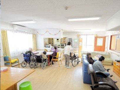 共有スペースで思い思いの席につき、好きなことをして過ごしている入居者の様子。