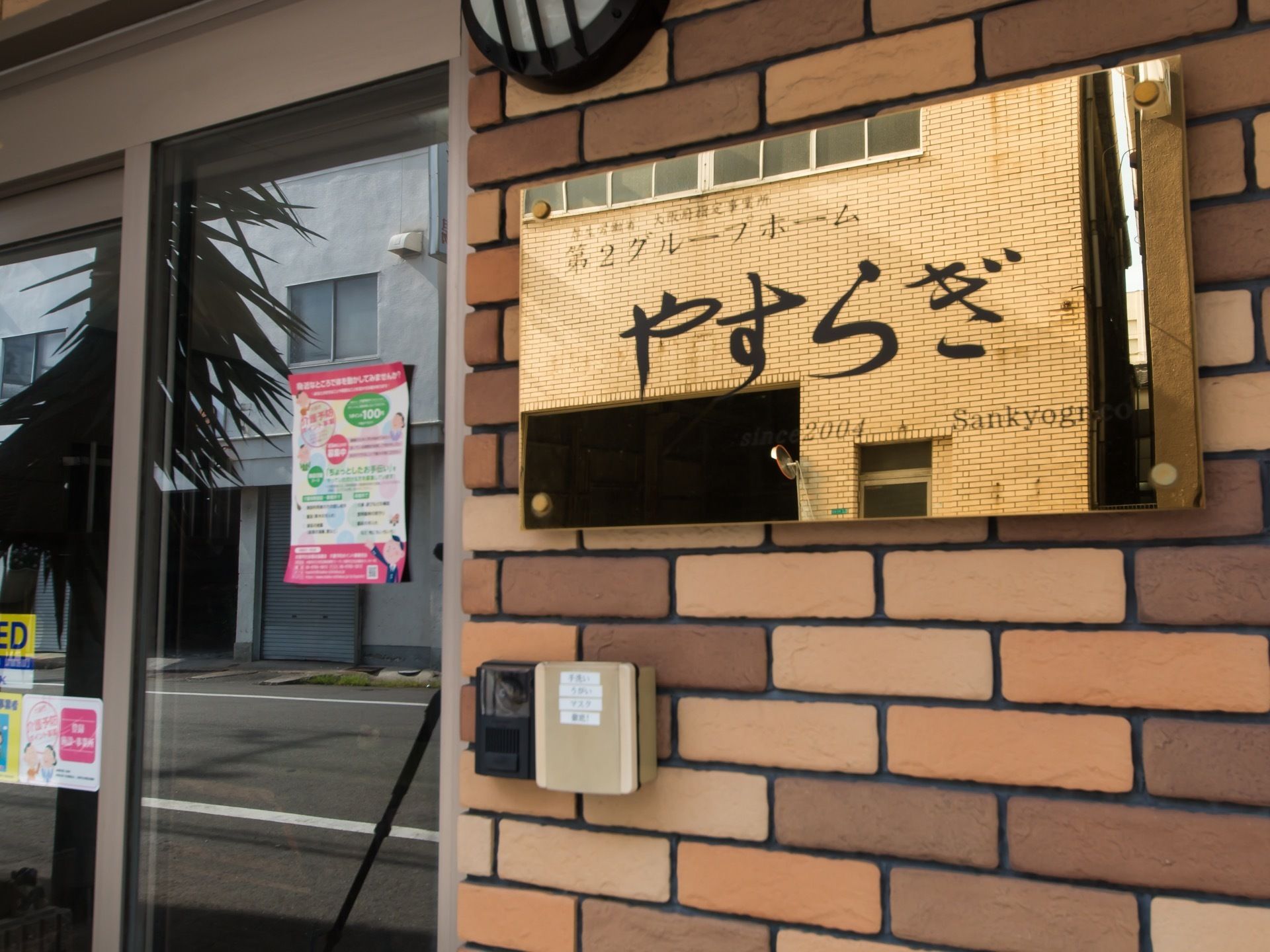 玄関扉の脇には、見やすい大きな施設の表札がつけられている。扉は簡単に出入りできる自動ドアになっている。