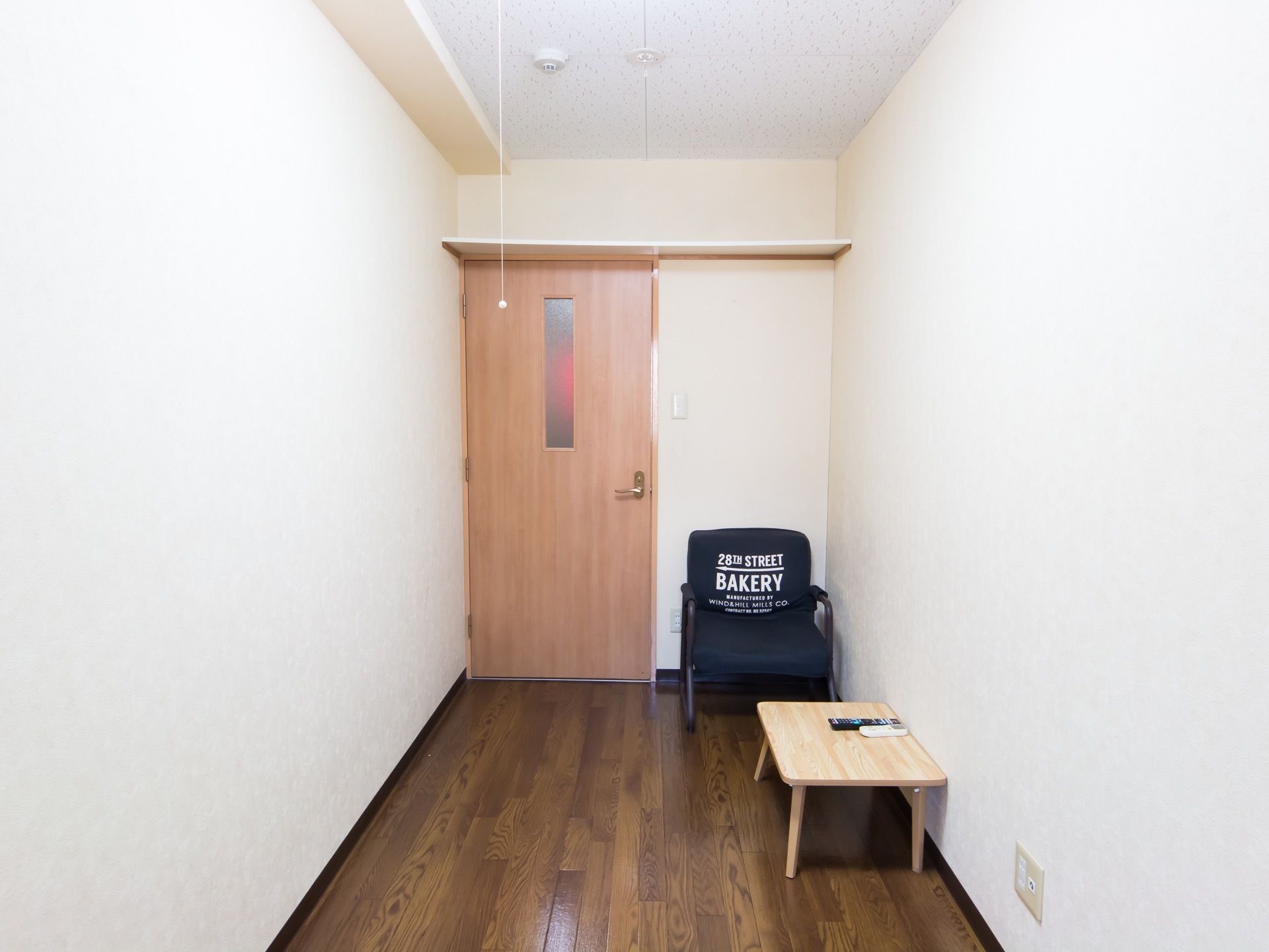 奥行きのある室内になっている。扉の上には収納が設けられている。テーブルや椅子など、お気に入りの家具を置ける。