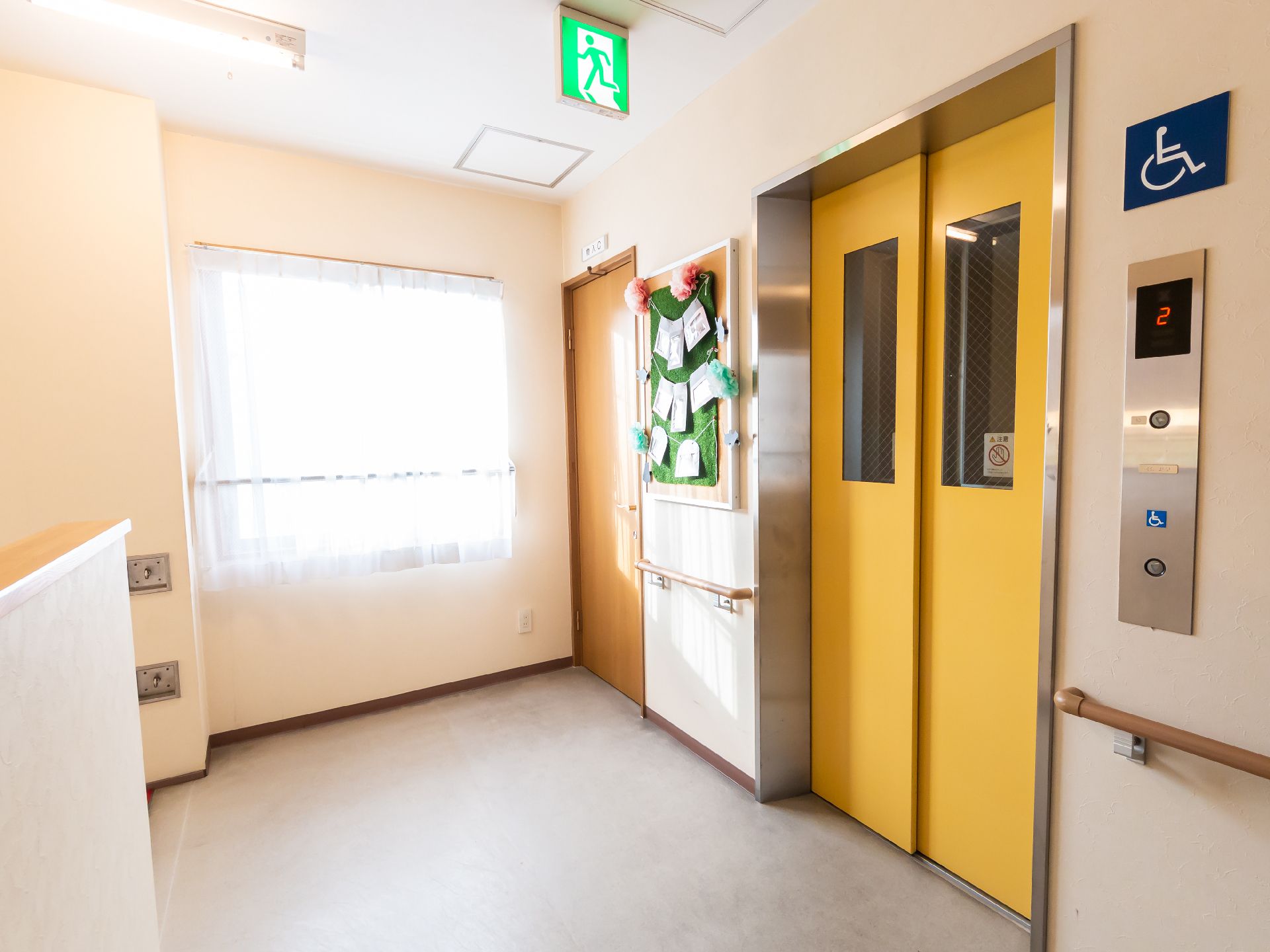 カルテのようなものを見ながら笑顔で話しているエプロンを付けた若い女性スタッフと高齢女性。