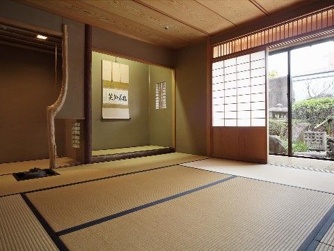 緑色の塗り壁でしつらえた床の間には飾り窓が付いており、掛け軸が掛かっている。水屋の床柱は自然の木の形を生かして作られている。