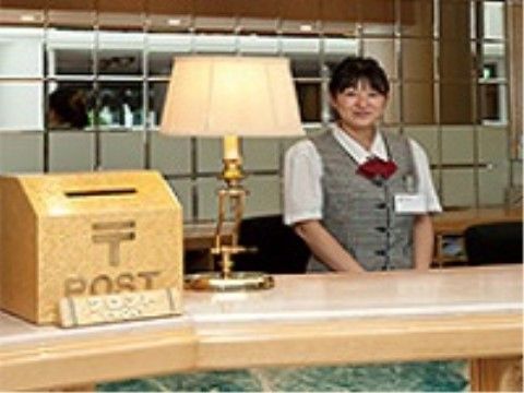 フロントのカウンターには昼光色の暖かみのあるランプが置かれている。その横には郵便マークのついたポストがある。