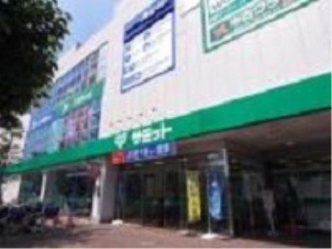 施設の近くに、白と緑がイメージカラーのスーパーがある。入り口前には広いスペースがあり、赤いレンガが敷かれている。