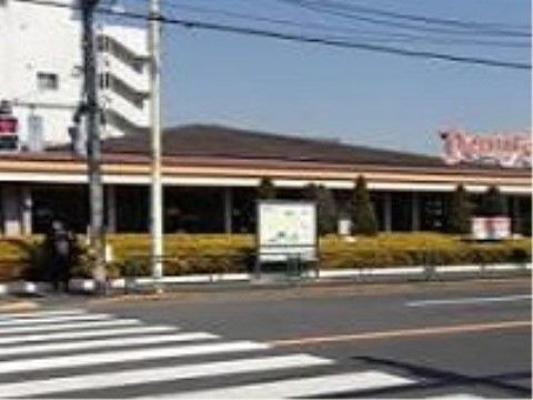 広い道路を挟んだ向こう側に、平屋造りで茶色い屋根をしたファミリーレストランがある。横断歩道が目の前にある。