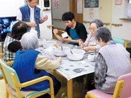 スタッフとレクリエーションを楽しんでいる様子。高齢者用施設の催し物を写した写真