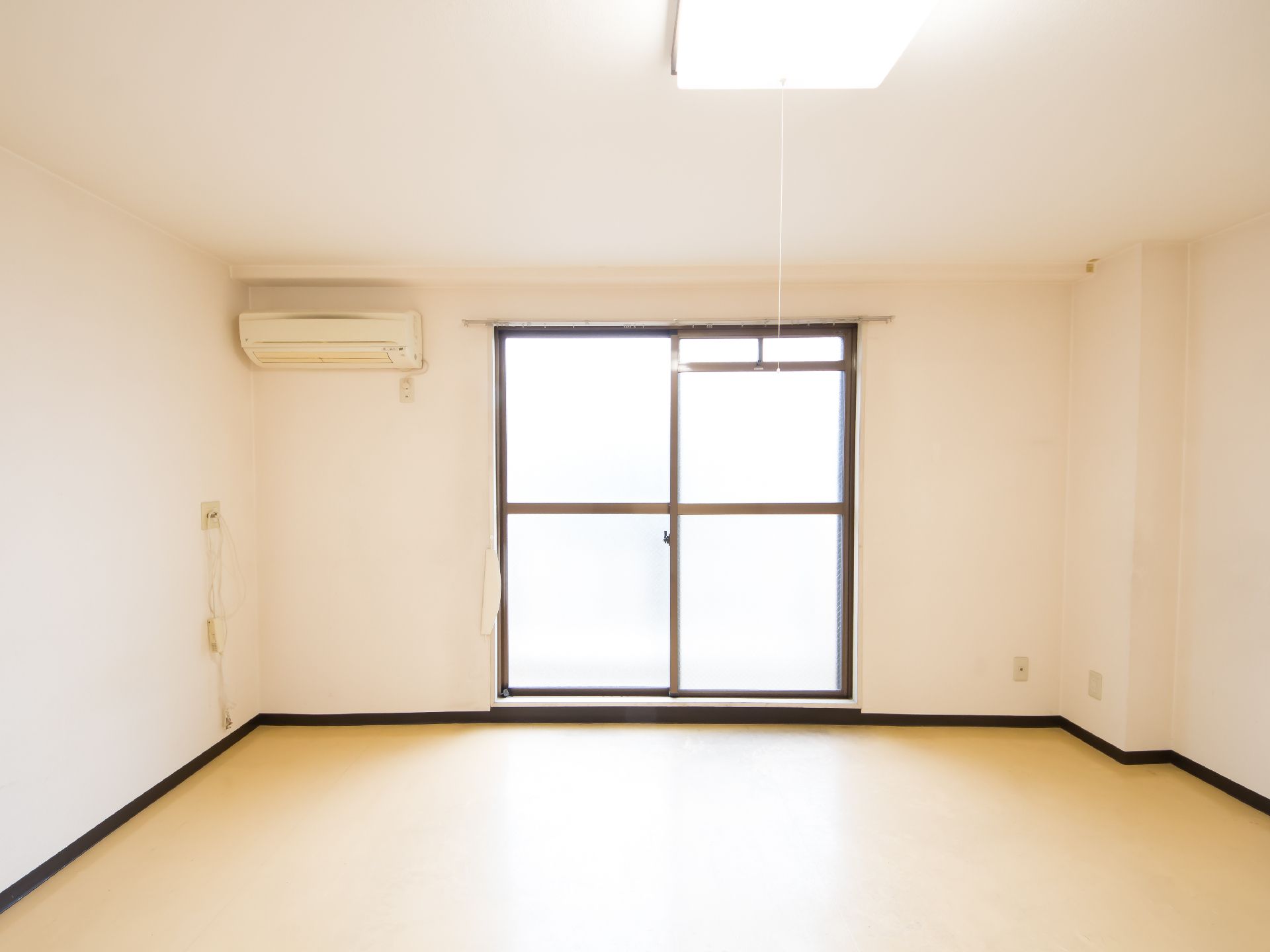 エアコンが設置されており、ガラス戸がある明るい居室