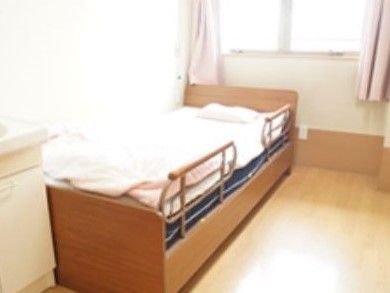 ベッドが置いてある小さな部屋の様子。手前に洗面台、奥のように窓がある様子