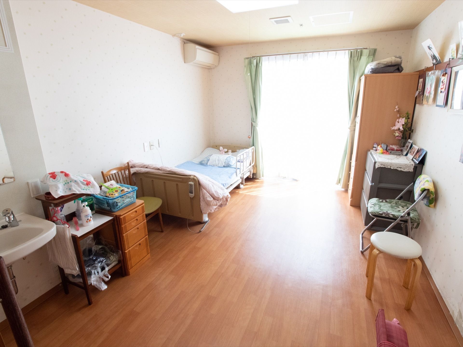 居室は広めの間取りになっている。介護ベッドやナースコール、エアコンが設置されている。洗面台も完備されている。