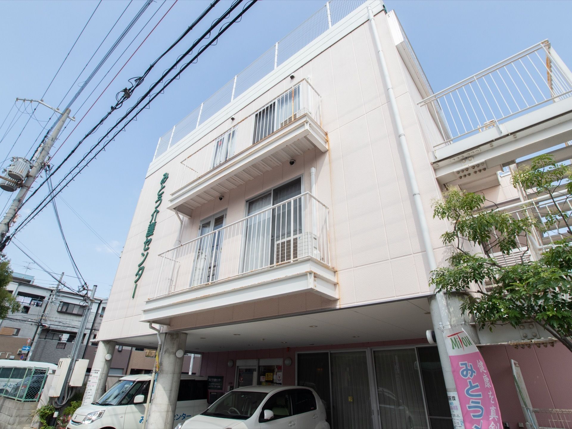 地上３階建ての施設である。１階部分に駐車スペースが設けられており、建物の右側面に外階段が設置されている。