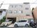 三階建ての建物の前に止まっている２台の車