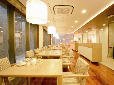 テーブルセットが並んだ食堂。奥行きがあり、大きな窓から自然光が入る。
