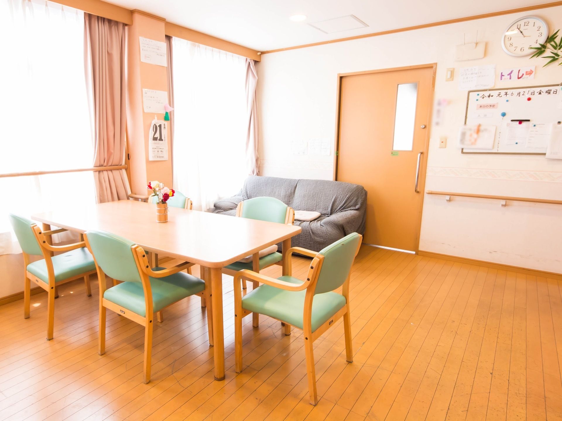窓のカーテン前にバーが設置してあり、壁にも手すりが取り付けてある。円柱形の脚をもつテーブルは、角が丸まっている。