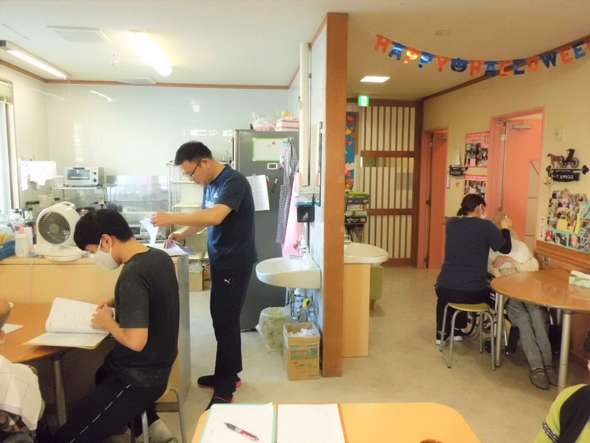 建物内で仕事をしているスタッフ。誰かに目線を合わせ、会話しようとしている。