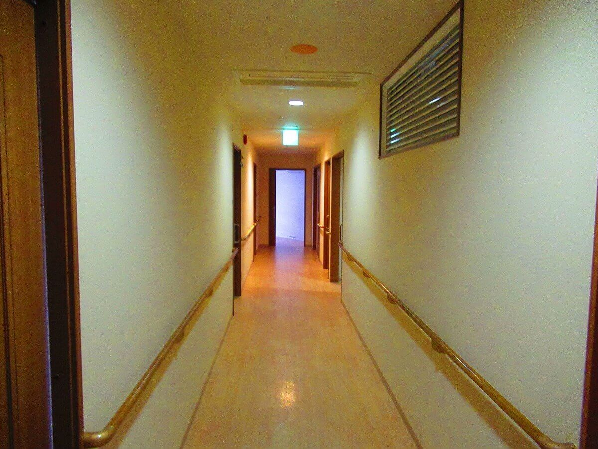 手すりが付いた廊下はまっすぐでフローリング。フロアには何もなく、安全に行き来ができる。