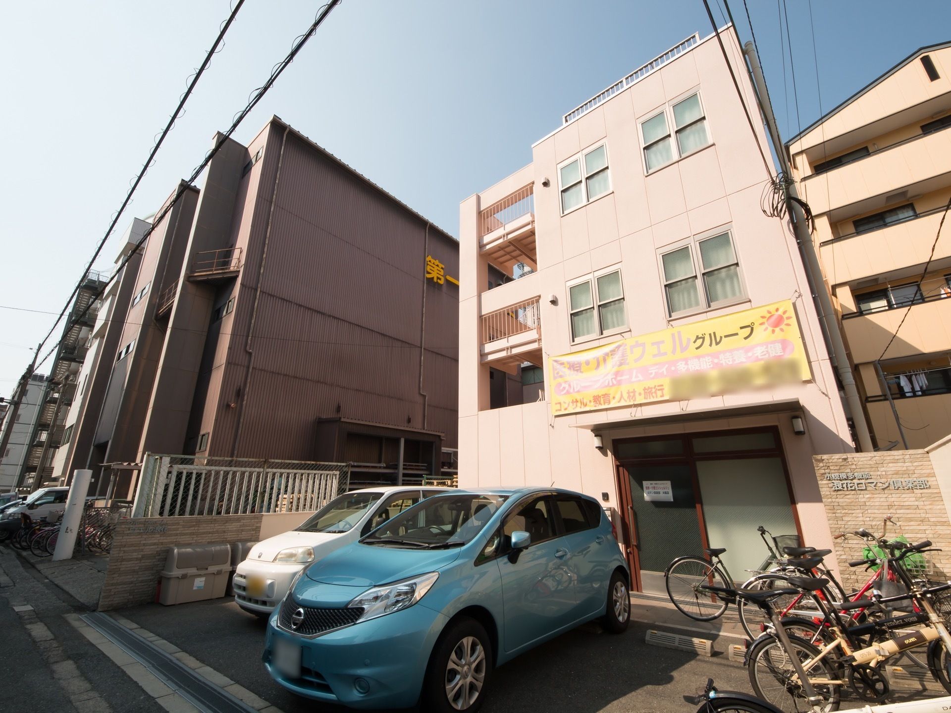 乗用車三台、自転車の駐車が可能で、鮮やかなピンク色の建物。わかりやすく、大きな文字で書かれた看板が目印となっている。