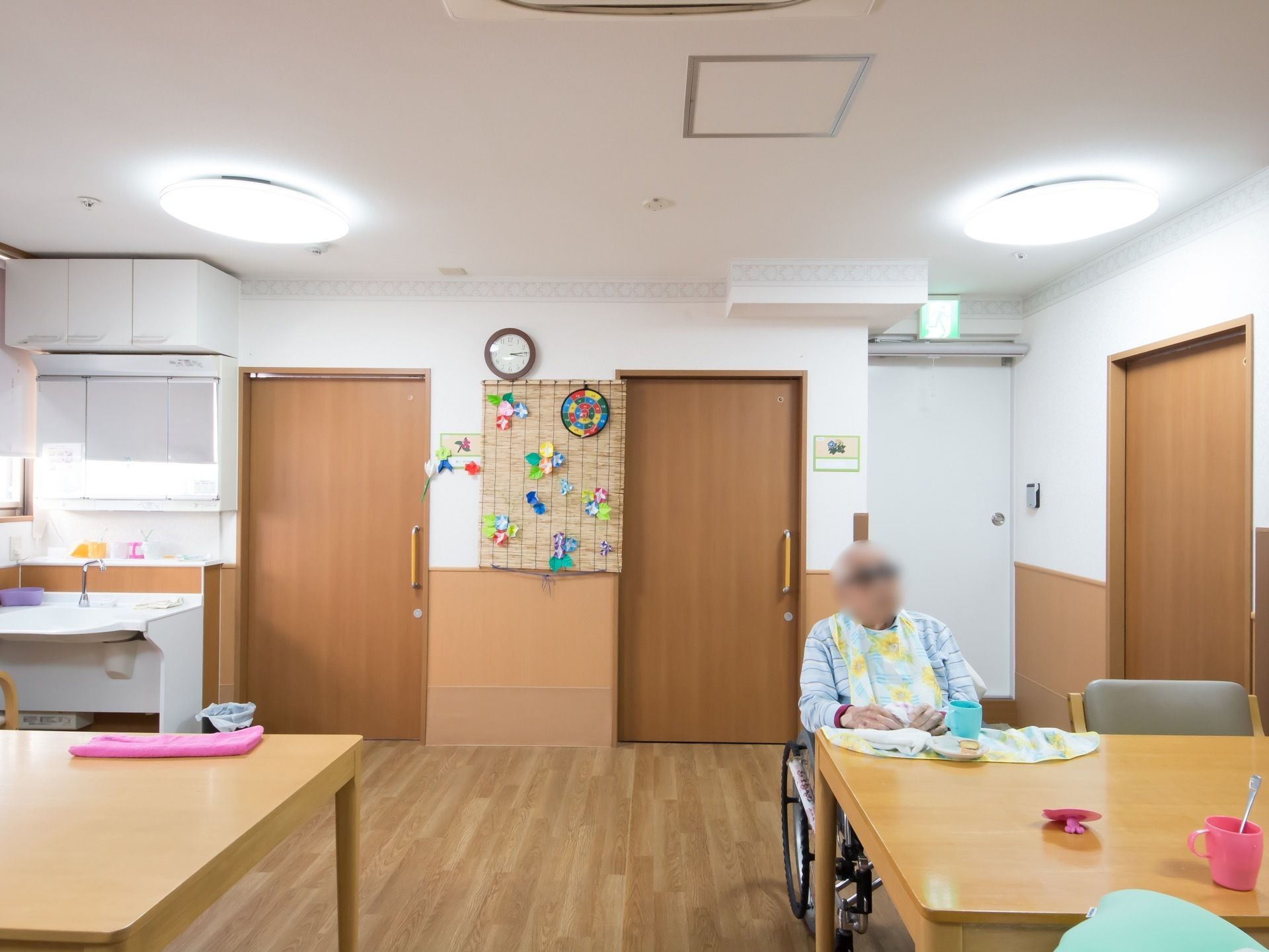 部屋は季節感のある装飾が施されている。段差のないスライドドアや大きなテーブルがあり、簡易的なキッチンも設置されている。