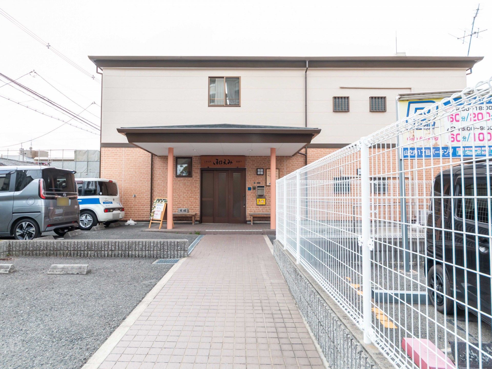 車椅子に乗った男性とその車椅子を押している女性が、自然の中で景色を眺めている。