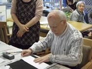習字を真剣なまなざしでしている男性入居者。