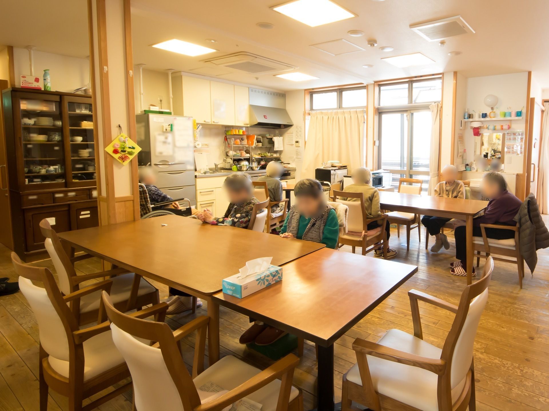 食堂には四角い木製のテーブルと肘掛け付きの椅子が複数設置されている。また床はフローリングになっている。