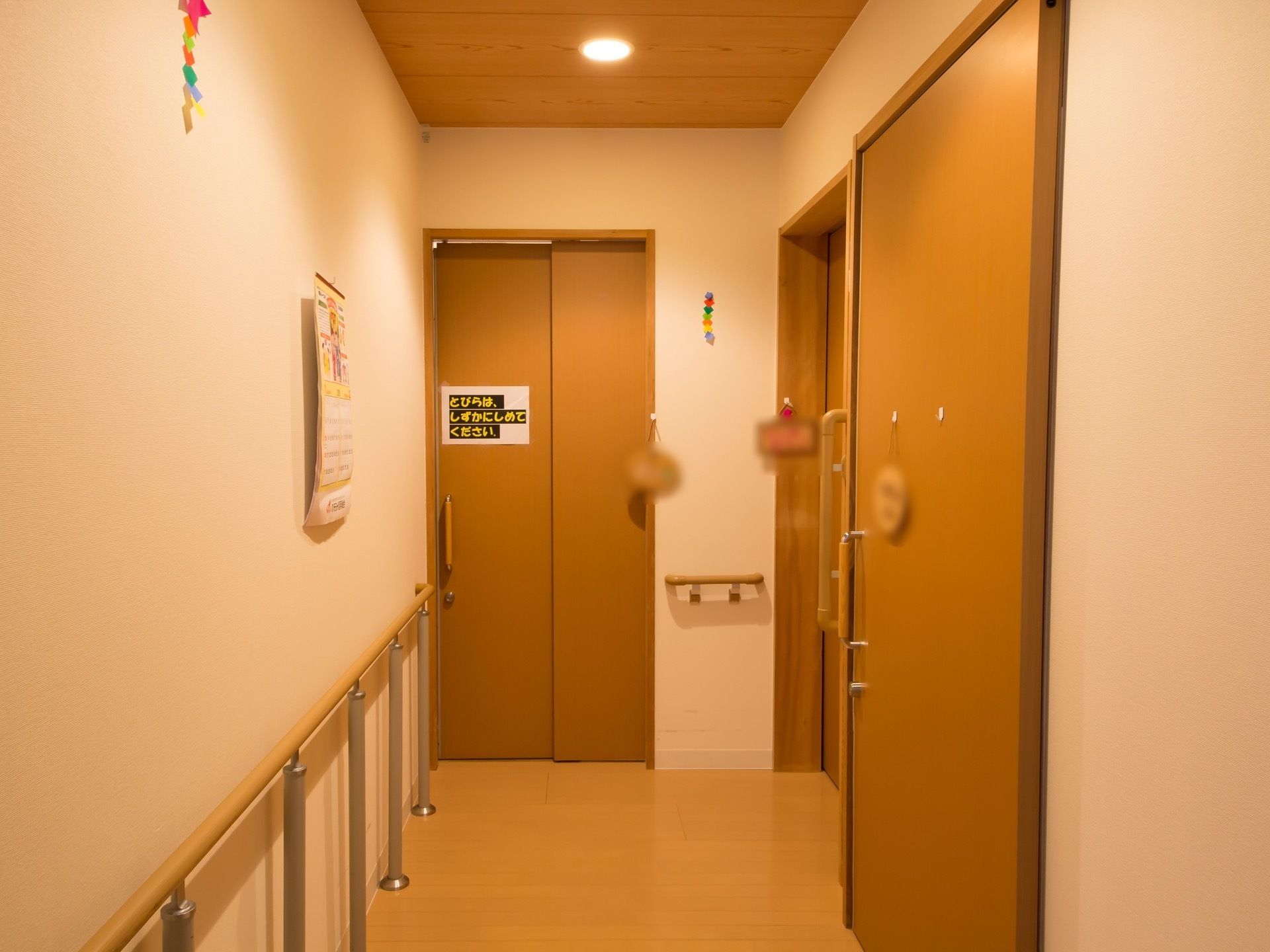 通路には3つの部屋の扉が並んでいる。1つの扉には、扉の開閉についての注意書きの紙が1枚貼られている。
