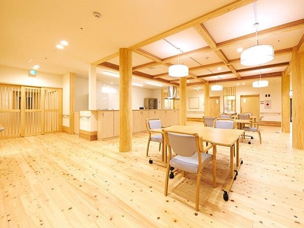 気をふんだんに使用した館内には木製のテーブルセットが複数置かれたリビングダイニングがある。