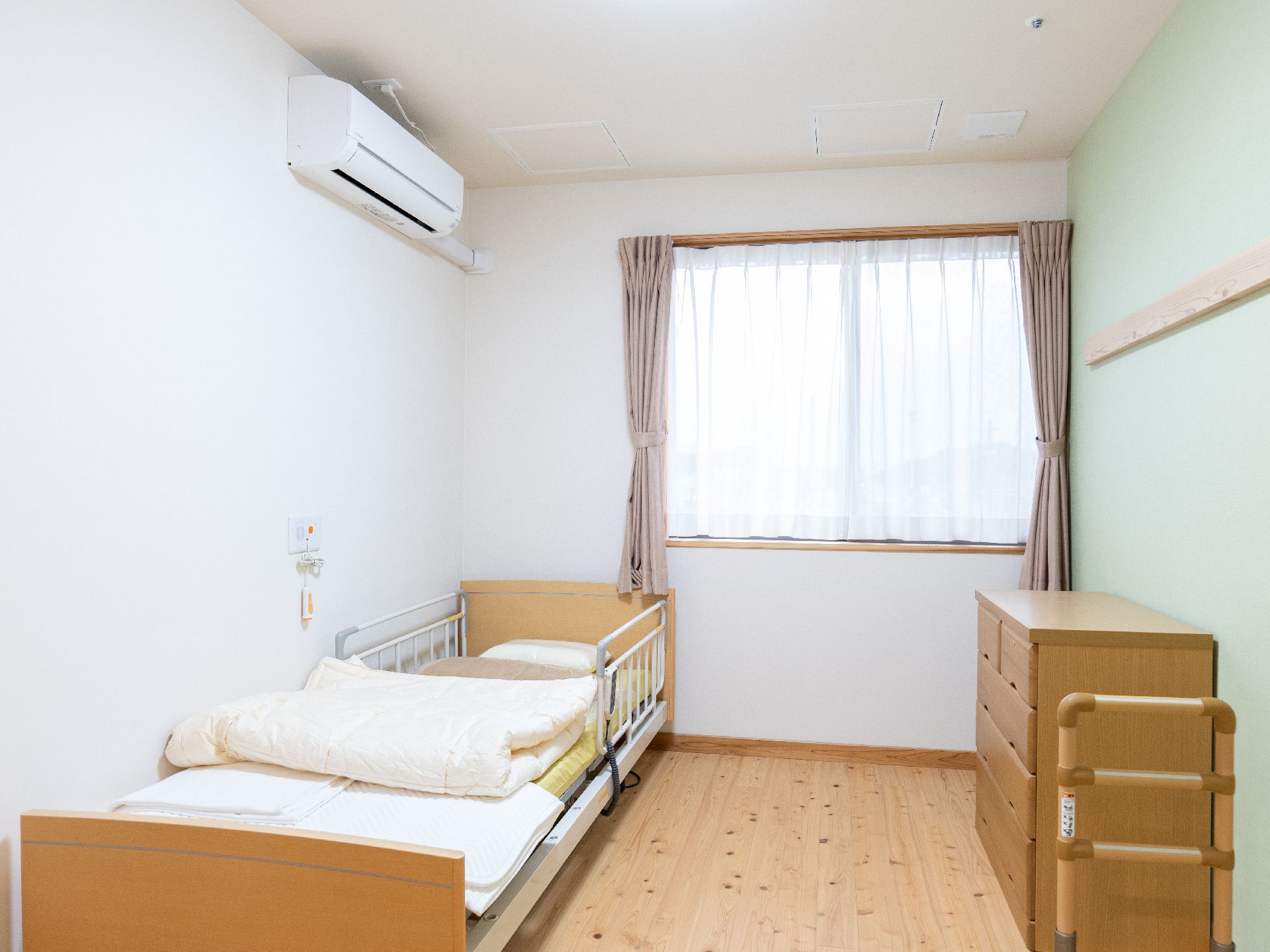 介護ベッドが設置され、家具や椅子が設置された居室