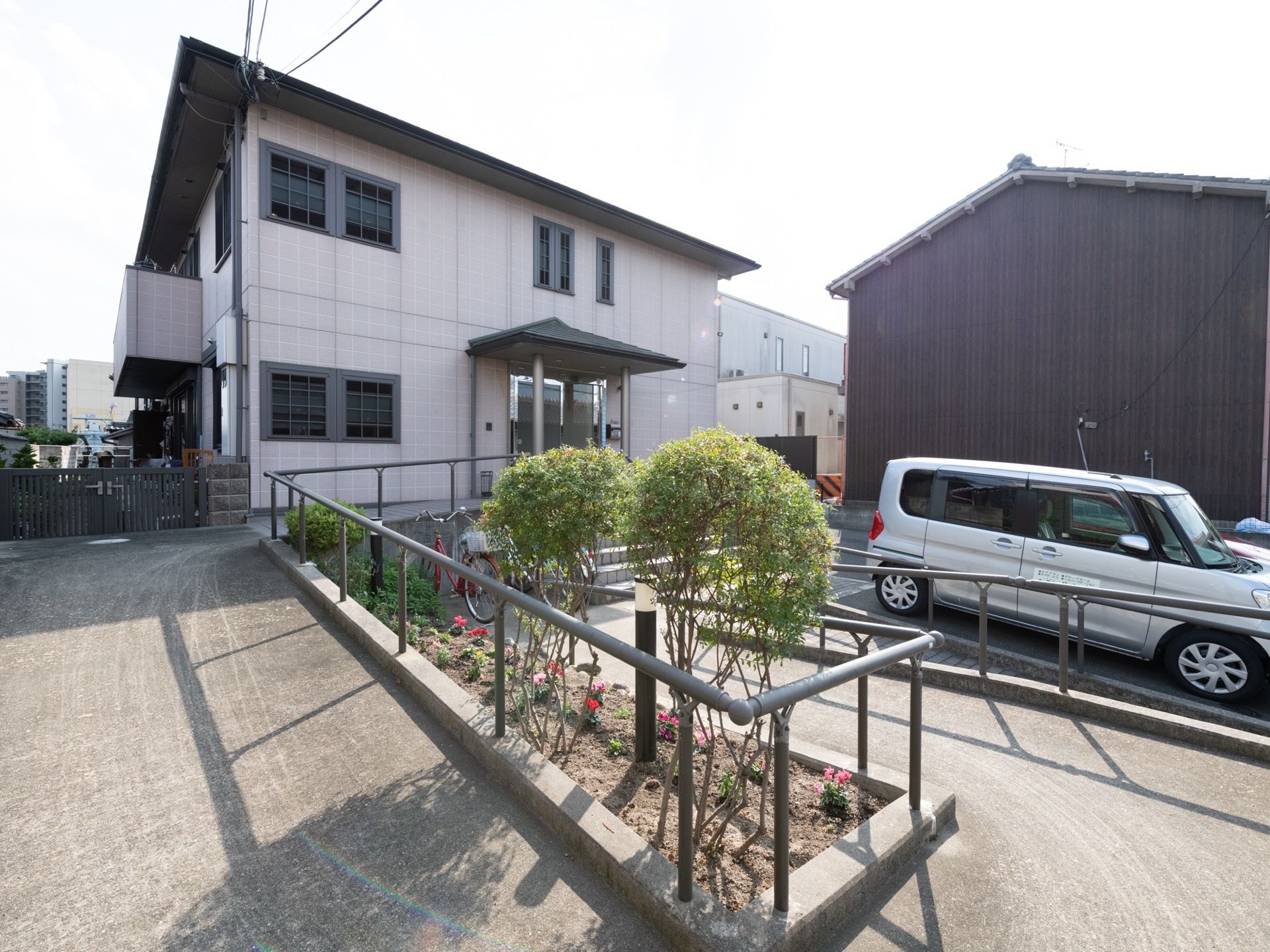２階建てのグループホームである。落ち着いた外観は、周囲の町並みにとけこんでいる。玄関へのアクセスはスロープになっている。