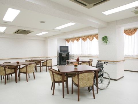 白を基調としたシンプルなリビングダイニング。見やすい位置にテレビが設置されており、テーブルの上に花が飾られている。